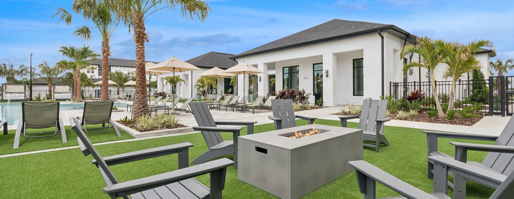 a backyard with lawn chairs and a firepit