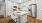 a kitchen with white cabinets a fridge a sink and a white island