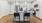 a kitchen with white cabinets and an island with bar chairs